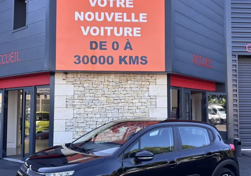 Citroën C3 PureTech 110 noir vue 3/4 avant droit, avec protections latérales blanches et jantes stylisées.