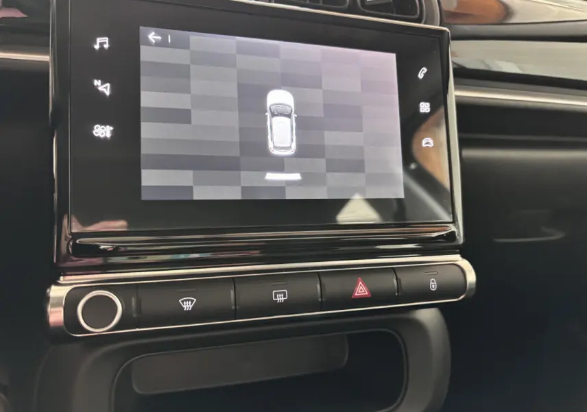 Écran tactile central affichant la vue aérienne du véhicule dans l'habitacle noir de la Citroën C3 PureTech 2024.
