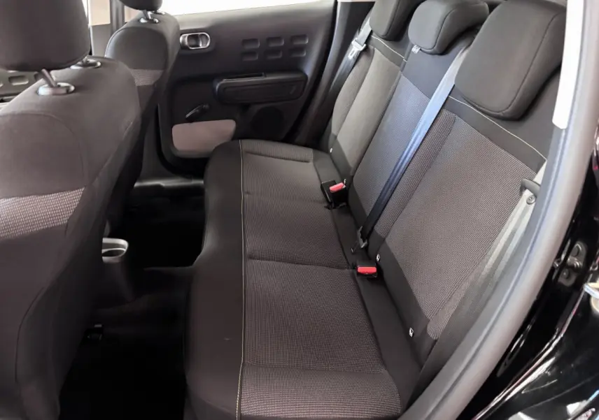 Vue intérieure côté droit des sièges arrière noirs de la Citroën C3 PureTech 110 BVM6 PLUS 2024 avec ceintures et appuie-têtes.