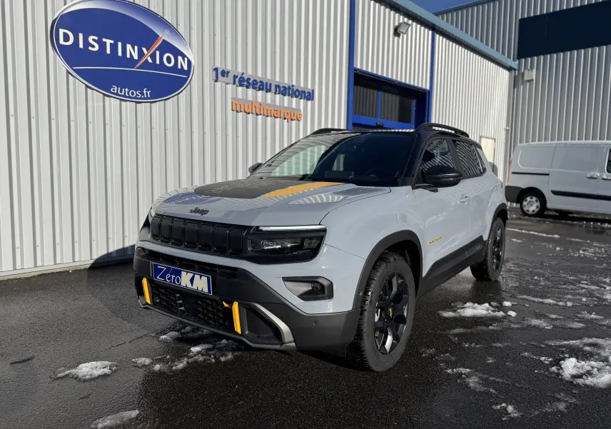 Jeep Avenger Storm Grey en 3/4 avant droit, avec toit noir et accents jaunes sur la calandre et le capot.