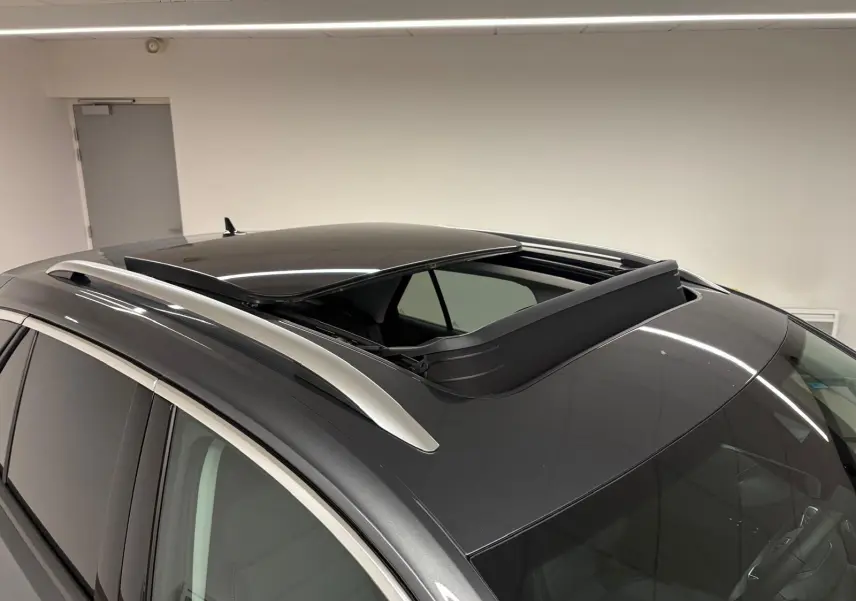 Toit ouvrant panoramique ouvert sur le dessus d’un Volkswagen T-Roc gris Indium vu en léger plongé intérieur.