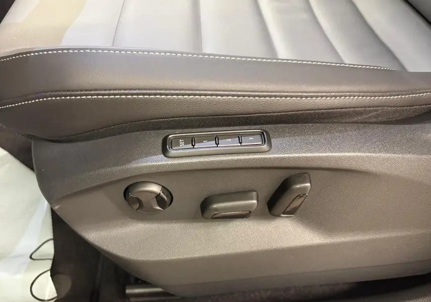 Détail des commandes de réglage électrique du siège conducteur en cuir noir du Volkswagen T-Roc 2025.