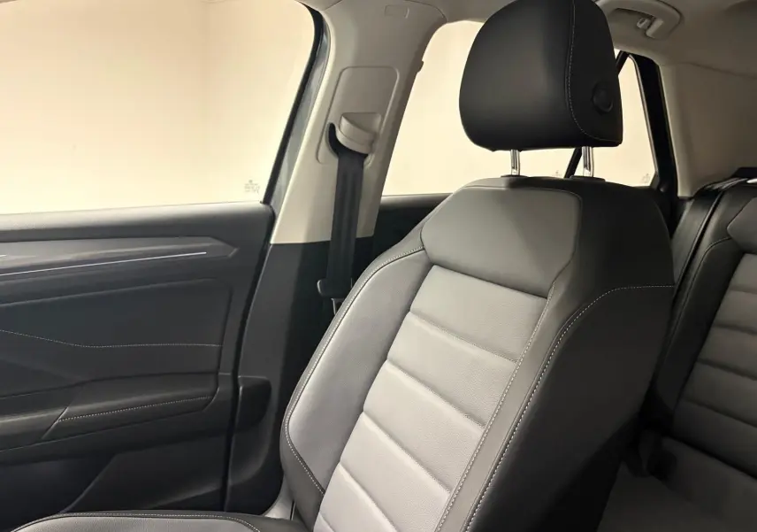 Gros plan sur le siège avant droit en cuir noir avec surpiqûres blanches dans l'habitacle du Volkswagen T-Roc 2025.