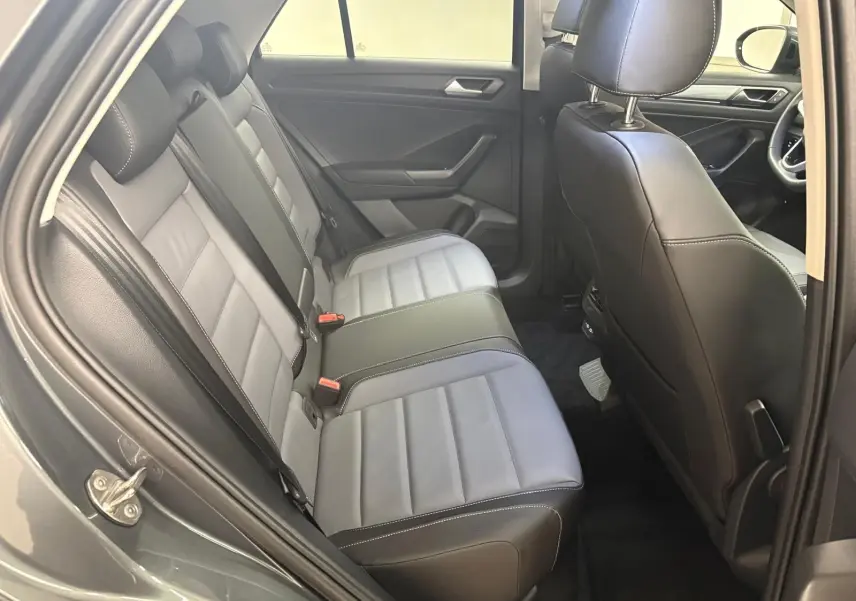 Vue intérieure côté gauche montrant la banquette arrière en cuir gris et noir du Volkswagen T-Roc 2025.