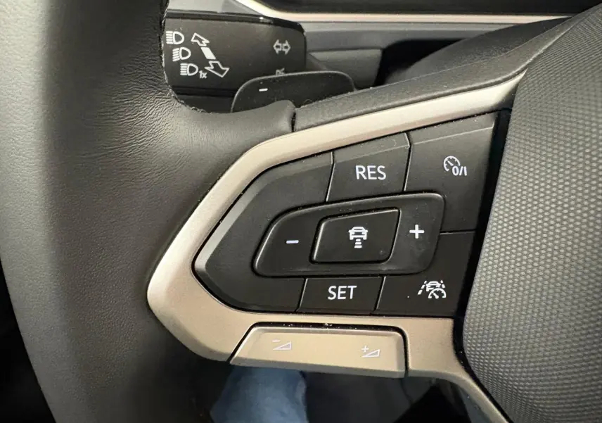 Gros plan sur les commandes de régulateur de vitesse au volant d’un Volkswagen T-Roc 2025, finition Style Exclusive.