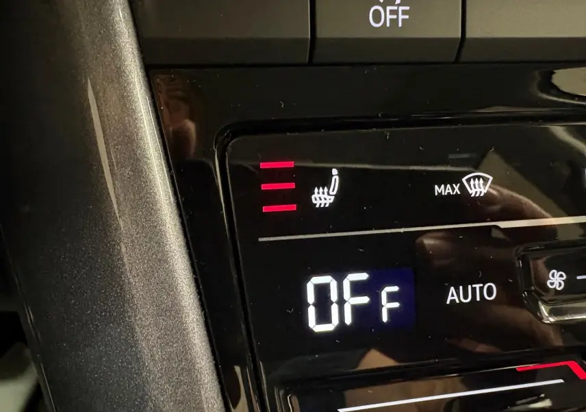 Vue 3/4 avant droit du Volkswagen T-Roc 2025 gris Indium avec attelage amovible visible à l'arrière.