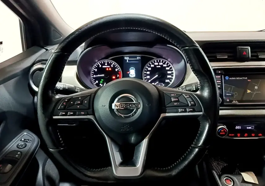 Vue intérieure centrée sur le volant cuir noir multifonctions et le tableau de bord digital de la Nissan Micra 2017.