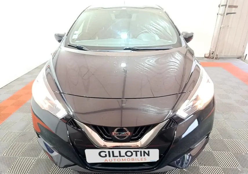 Vue avant d'une Nissan Micra IG-T 90 N-Connecta noire, avec phares allumés et calandre chromée visible.