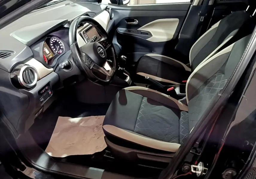 Intérieur avant droit de la Nissan Micra IG-T 90 N-Connecta 2017 noire, volant cuir multifonctions et tableau de bord tactile.