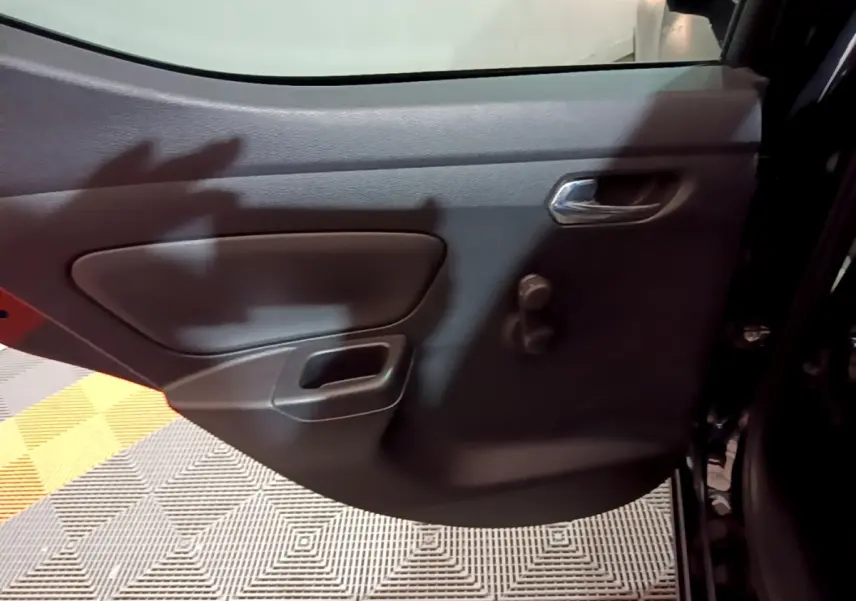 Vue rapprochée de la porte intérieure côté droit noire de la Nissan Micra IG-T 90 N-Connecta 2017 avec poignée chromée.