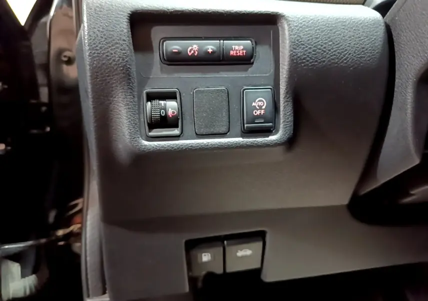 Détail du tableau de bord côté gauche de la Nissan Micra IG-T 90 N-Connecta noire avec commandes d'éclairage et ouverture.