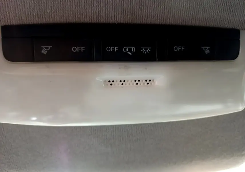 Vue rapprochée du plafonnier gris clair avec boutons de commande d’éclairage dans une Nissan Micra noire 2017.