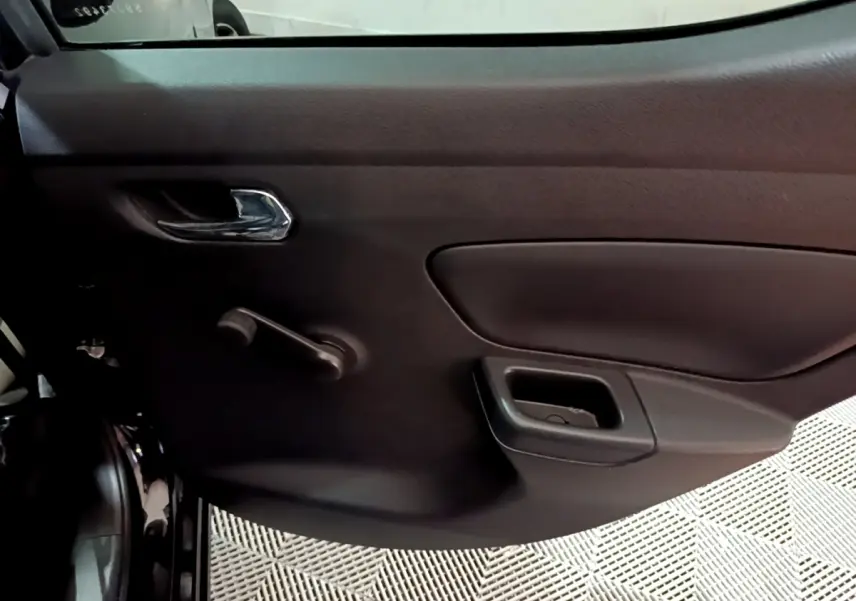 Vue intérieure côté gauche de la porte arrière noire de la Nissan Micra 2017 avec poignée chromée et manivelle de vitre.