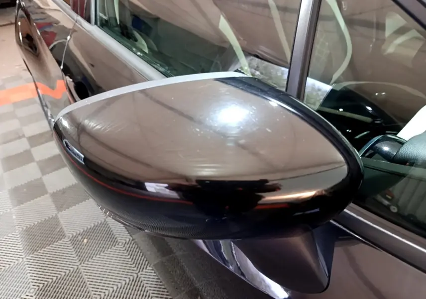 Rétroviseur côté gauche noir brillant d’une Nissan Micra IG-T 90 N-Connecta 2017, vue rapprochée en intérieur.