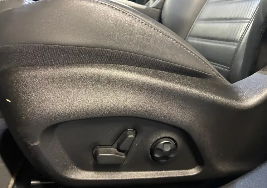 Détail des commandes de réglage électrique du siège conducteur en cuir noir de l'Alfa Romeo Tonale 2022.