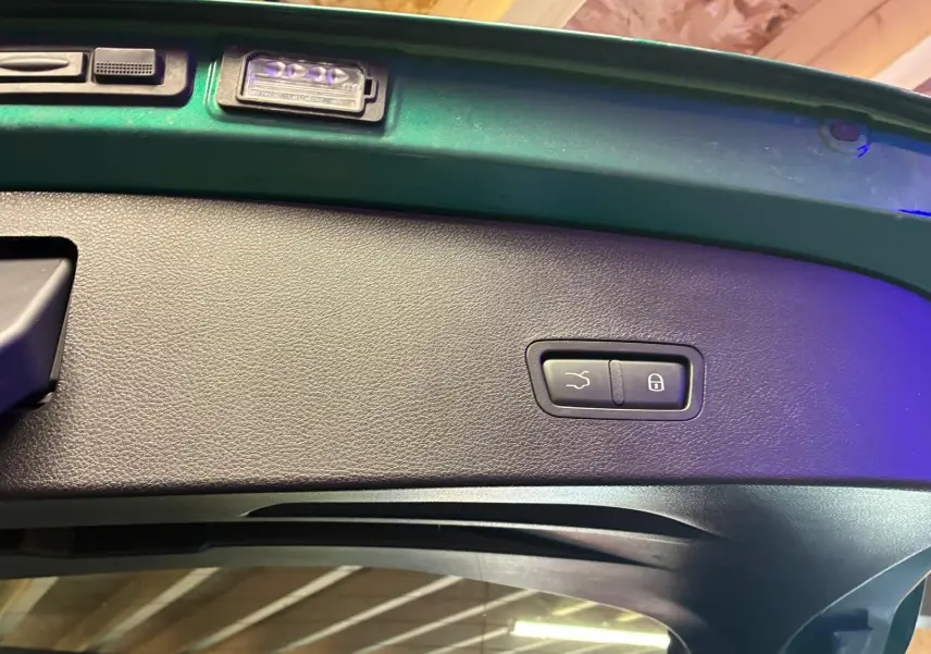 Détail intérieur du hayon vert foncé d'une Alfa Romeo Tonale 2022, avec boutons de fermeture et verrouillage intégrés.