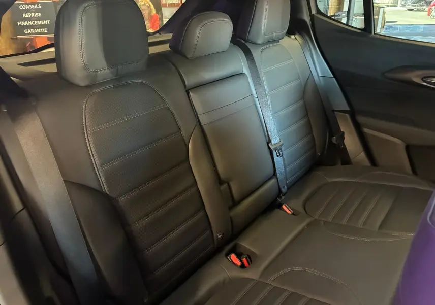 Vue intérieure arrière de l'Alfa Romeo Tonale 2022, sièges en cuir noir avec ceintures et appuie-têtes visibles.