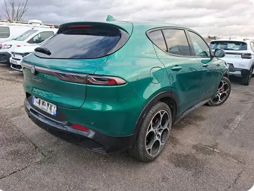 Alfa Romeo Tonale vert foncé en 3/4 avant droit, avec jantes distinctives et calandre triangulaire emblématique.