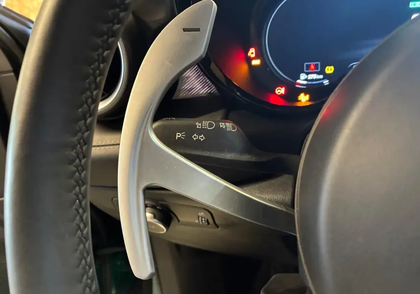 Gros plan sur la palette de changement de vitesse grise côté gauche du volant d’un Alfa Romeo Tonale 2022, intérieur noir.