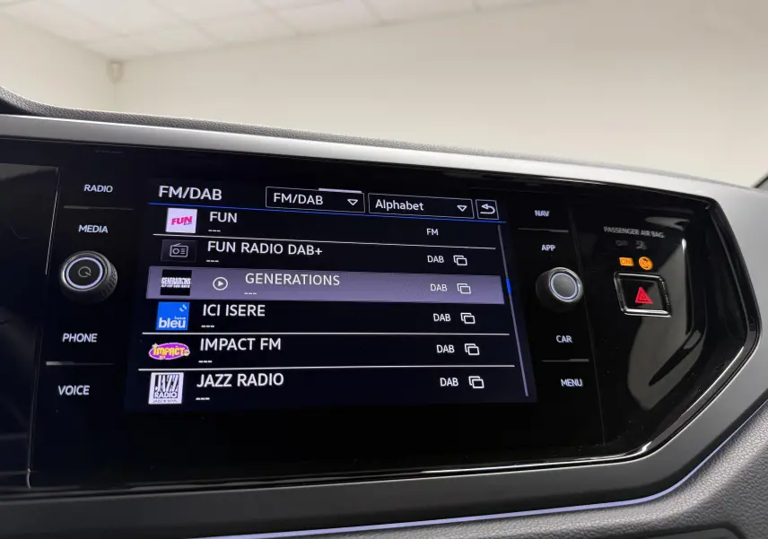 Écran tactile central du Volkswagen Taigo 2025 affichant les stations radio DAB+ avec interface noire brillante.