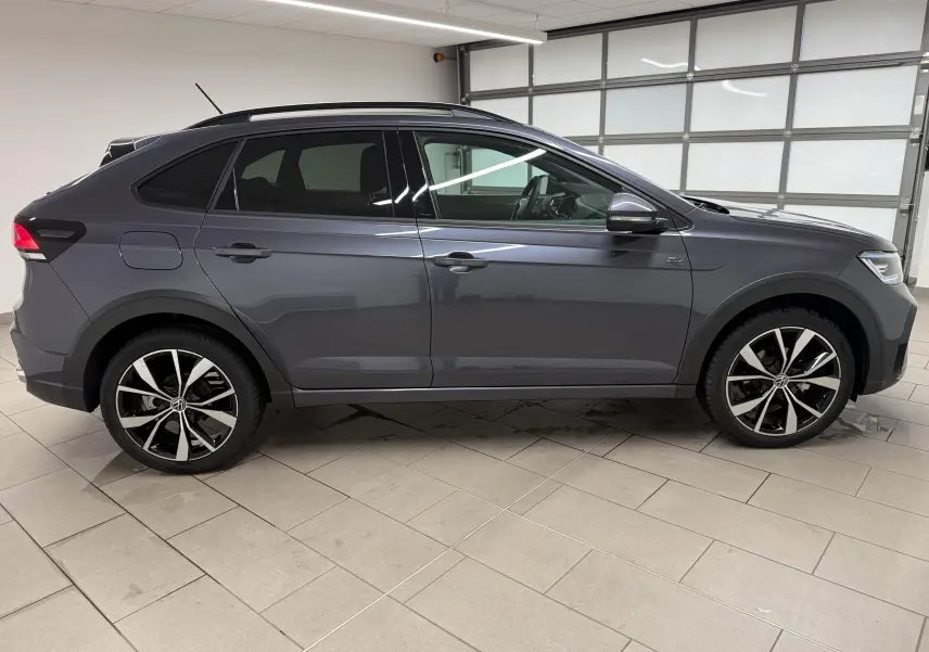 Vue de profil droit du Volkswagen Taigo gris cendre avec jantes alliage 18 pouces et finitions R-Line en intérieur.