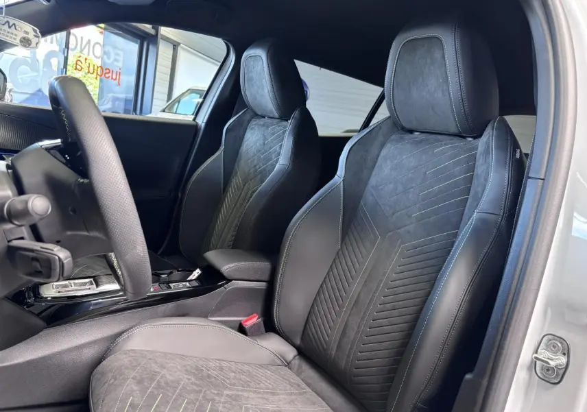 Vue intérieure côté gauche des sièges avant en Alcantara noir avec surpiqûres vertes dans un Peugeot 2008 hybride 2026.
