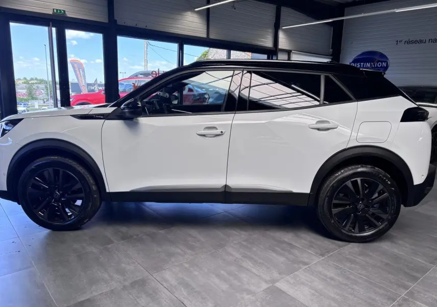 Peugeot 2008 hybride 2026 vue de profil côté gauche, carrosserie blanche avec toit et jantes noires.