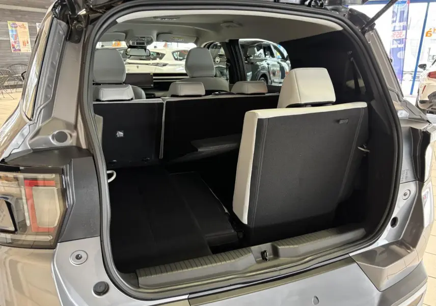Vue arrière du coffre ouvert du Citroën C3 Aircross gris, montrant la banquette 7 places avec siège arrière partiellement relevé.
