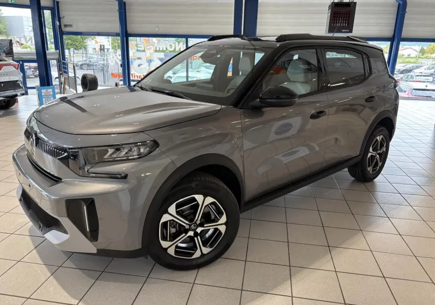 Vue 3/4 avant droite du Citroën C3 Aircross 2026 gris métallisé avec toit noir et jantes alliage diamantées.