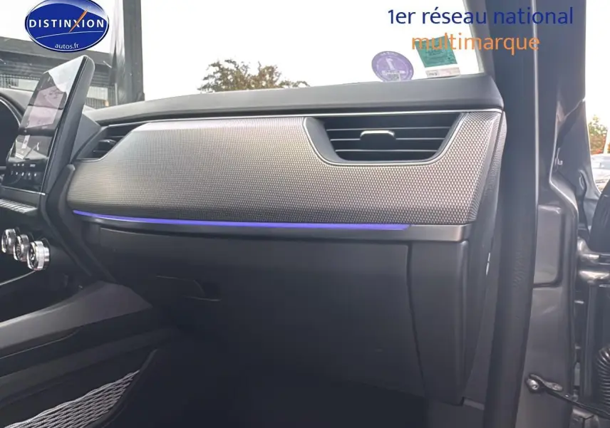 Intérieur côté passager du Renault Arkana gris 2022, tableau de bord avec éclairage d'ambiance bleu et finition texturée.