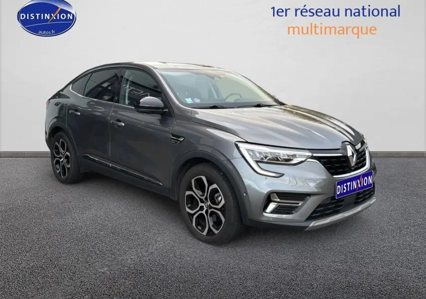 Renault Arkana gris en 3/4 avant droit, avec jantes alu distinctives et calandre moderne.