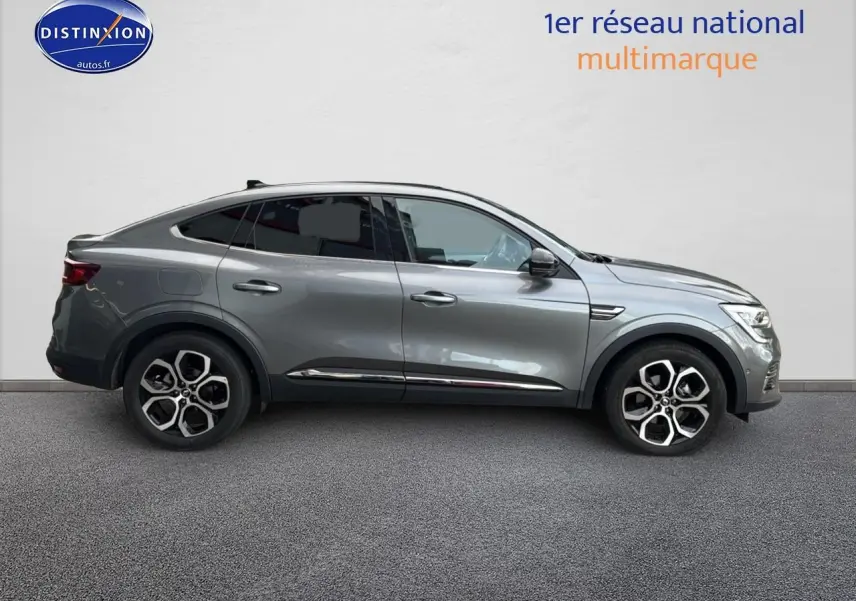 Profil droit d'un Renault Arkana gris 2022 avec jantes alliage et vitres arrière surteintées.