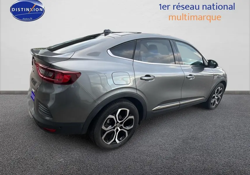 Vue 3/4 arrière droite d'un Renault Arkana gris avec jantes alliage et vitres teintées sur fond neutre.