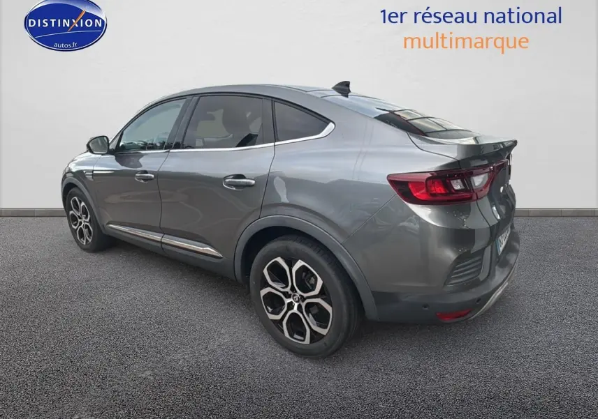 Vue 3/4 arrière droite d’un Renault Arkana gris avec jantes alliage et vitres teintées sur fond neutre.