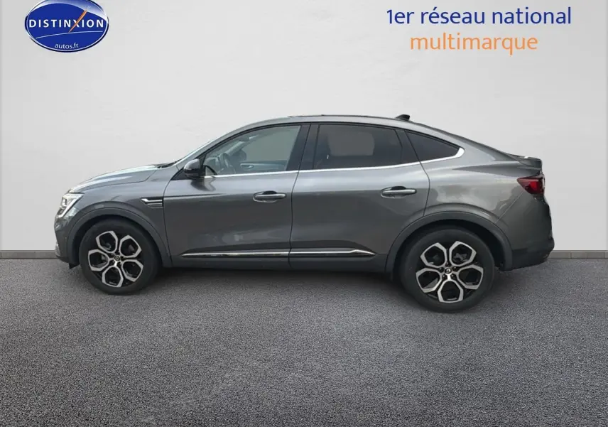 Vue latérale droite d'un Renault Arkana gris 2022 avec jantes alu au design distinctif et lignes fluides.