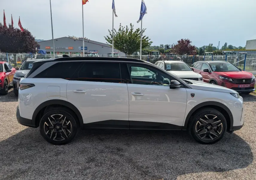 Vue de profil côté gauche d’un Peugeot 5008 blanc 2025 avec toit noir et jantes alliage noires diamantées.