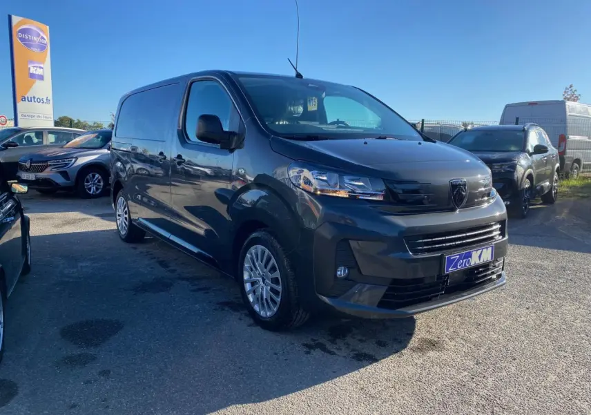 Peugeot Expert Fourgon gris titane vu en 3/4 avant droit avec jantes tôle et calandre noire brillante.