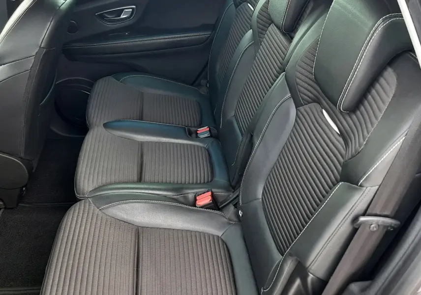 Vue intérieure côté conducteur du Renault Scénic IV 2020, sièges noirs en cuir et tissu avec surpiqûres blanches.