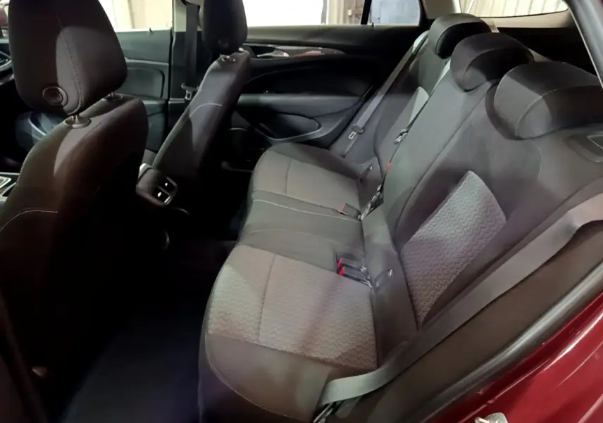 Vue intérieure côté droit des sièges arrière en tissu gris d’une Opel Insignia rouge, avec ceinture de sécurité visible.