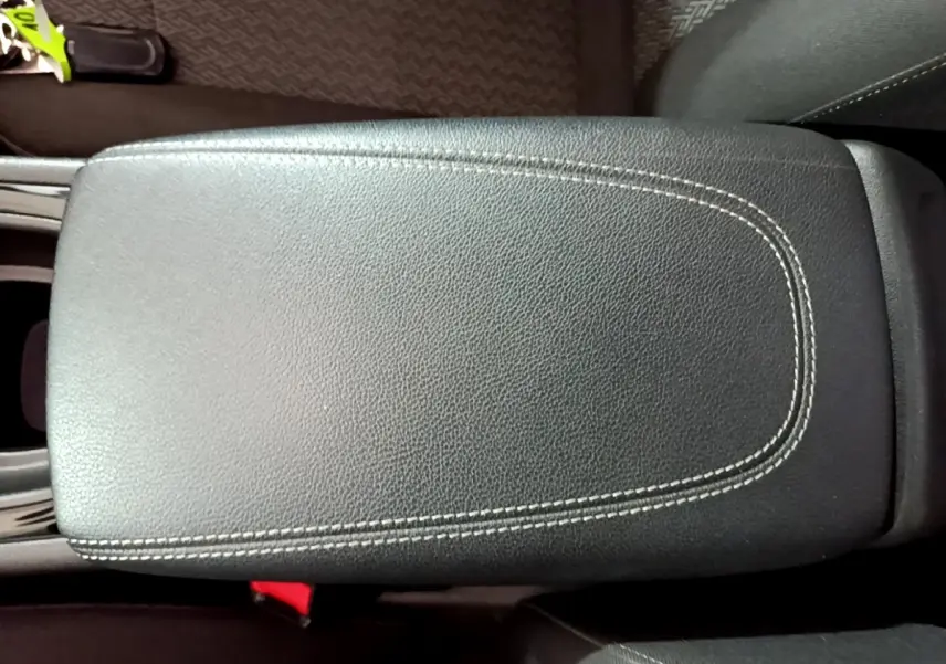 Gros plan sur l'accoudoir central en cuir noir avec surpiqûres blanches de l'Opel Insignia 2019.