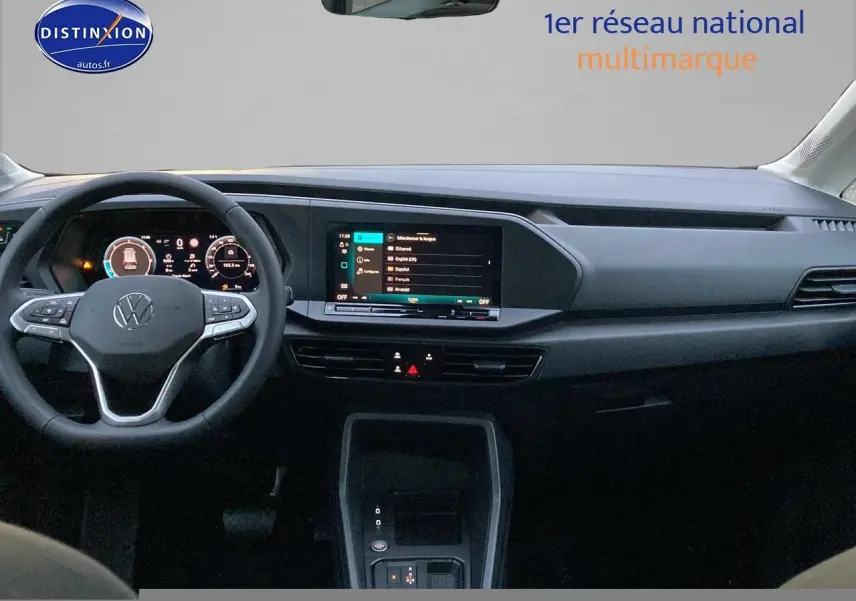 Vue intérieure frontale du tableau de bord noir du Volkswagen Caddy 2025 avec écran tactile et volant multifonction.