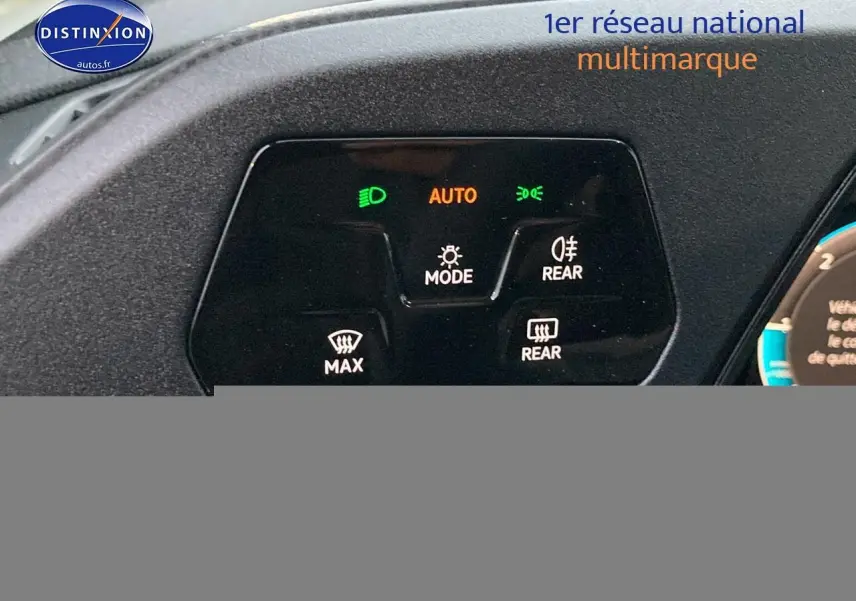 Gros plan sur le panneau de commande des feux et dégivrage du Volkswagen Caddy bleu métallisé, avec affichage lumineux des fonctions.