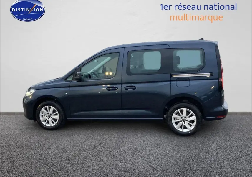 Profil côté gauche d'un Volkswagen Caddy bleu métallisé 2025 avec jantes alliage et vitres teintées arrière.