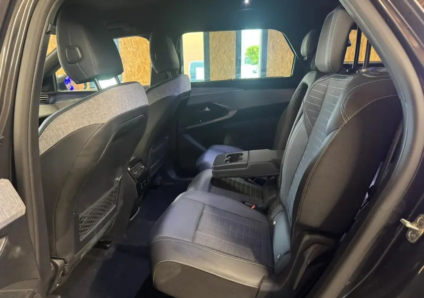 Vue intérieure côté droit des sièges arrière en tissu noir avec accoudoir central du Peugeot 5008 1.2 Hybrid 136 GT 2025.
