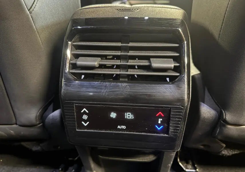 Vue rapprochée de la console arrière du Peugeot 5008 gris, avec commandes de climatisation digitale affichant 18,5°C.