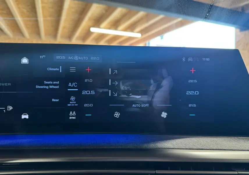 Écran tactile central du Peugeot 5008 gris 2025 montrant les réglages de climatisation avec ambiance lumineuse bleue.