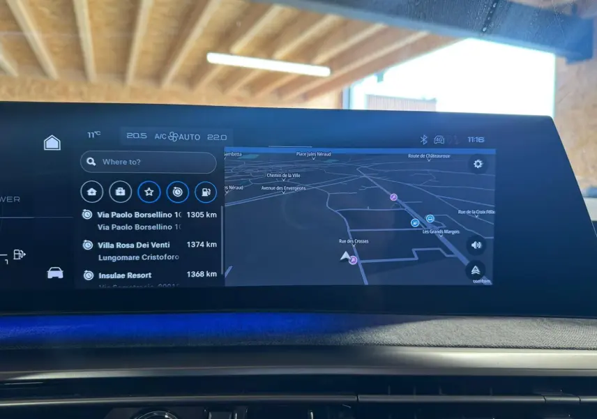 Écran tactile intérieur du tableau de bord du Peugeot 5008 gris 1.2 Hybrid 136 GT, affichant la navigation GPS.