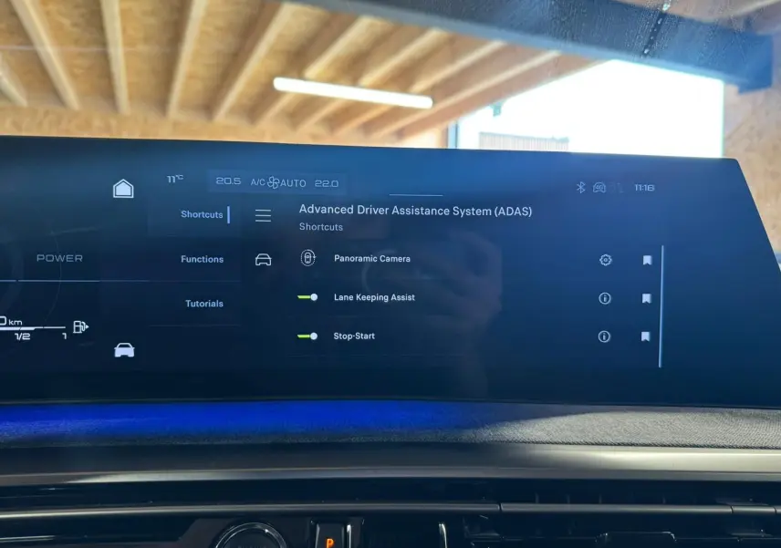 Écran tactile du système d'assistance avancée du conducteur dans l'habitacle du Peugeot 5008 gris, version 2025.