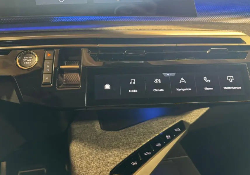 Vue rapprochée de la console centrale noire du Peugeot 5008 gris 1.2 Hybrid 136 GT, avec écran tactile et bouton start/stop.