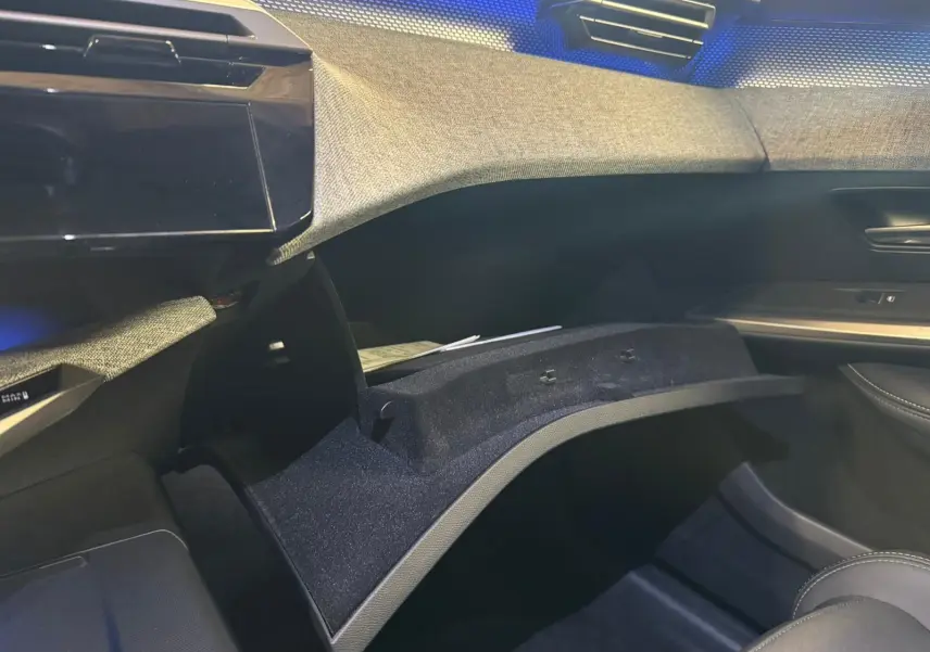 Vue intérieure côté passager du tableau de bord gris et tissu noir avec boîte à gants ouverte du Peugeot 5008 1.2 Hybrid 136 GT 2025.